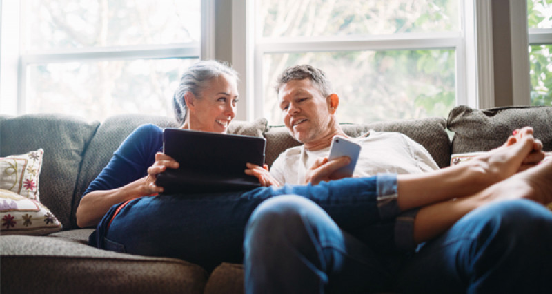 Couple on couch looking at a laptop