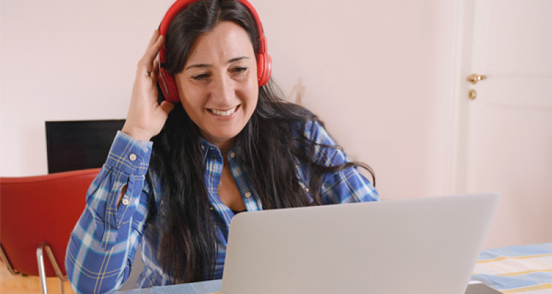 Woman with headphones watching a laptop computer